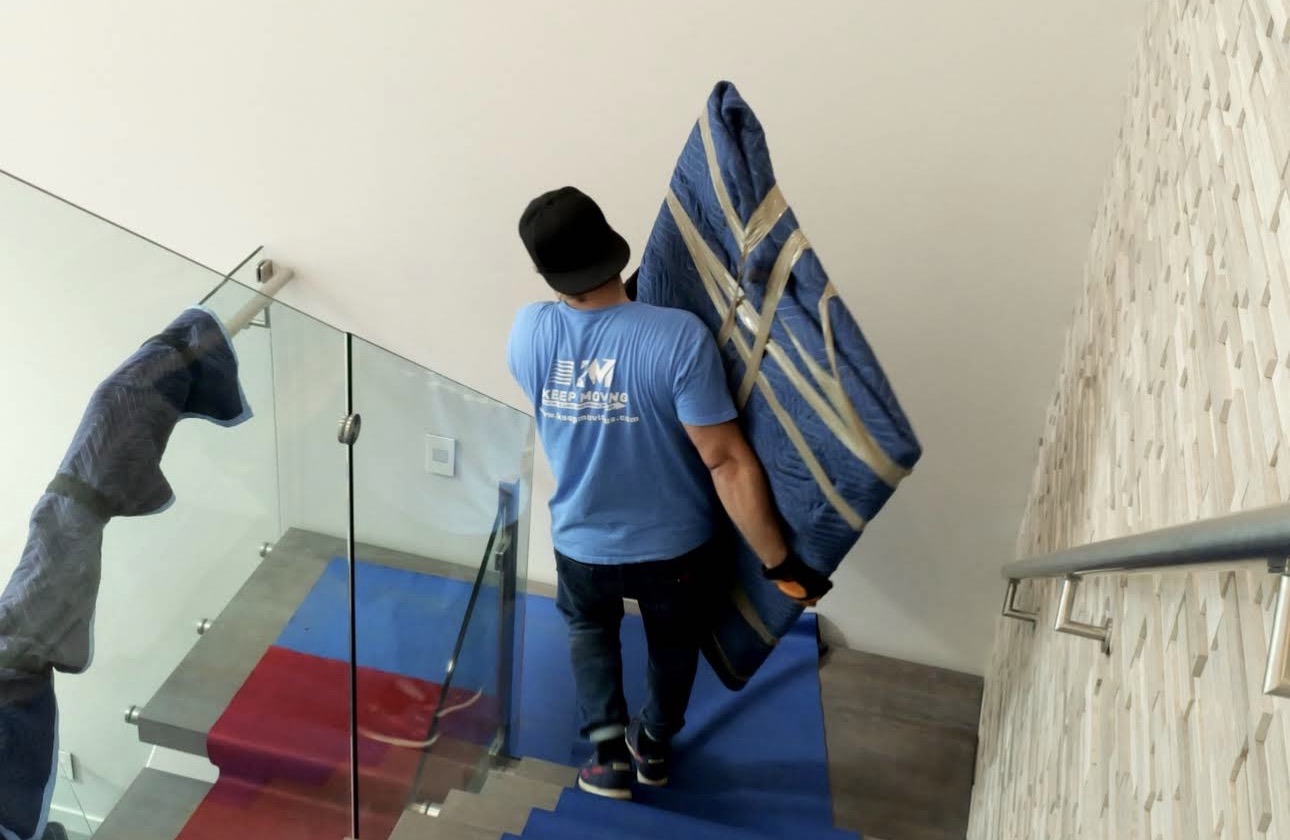 Mover taking a wall painting to the moving truck.